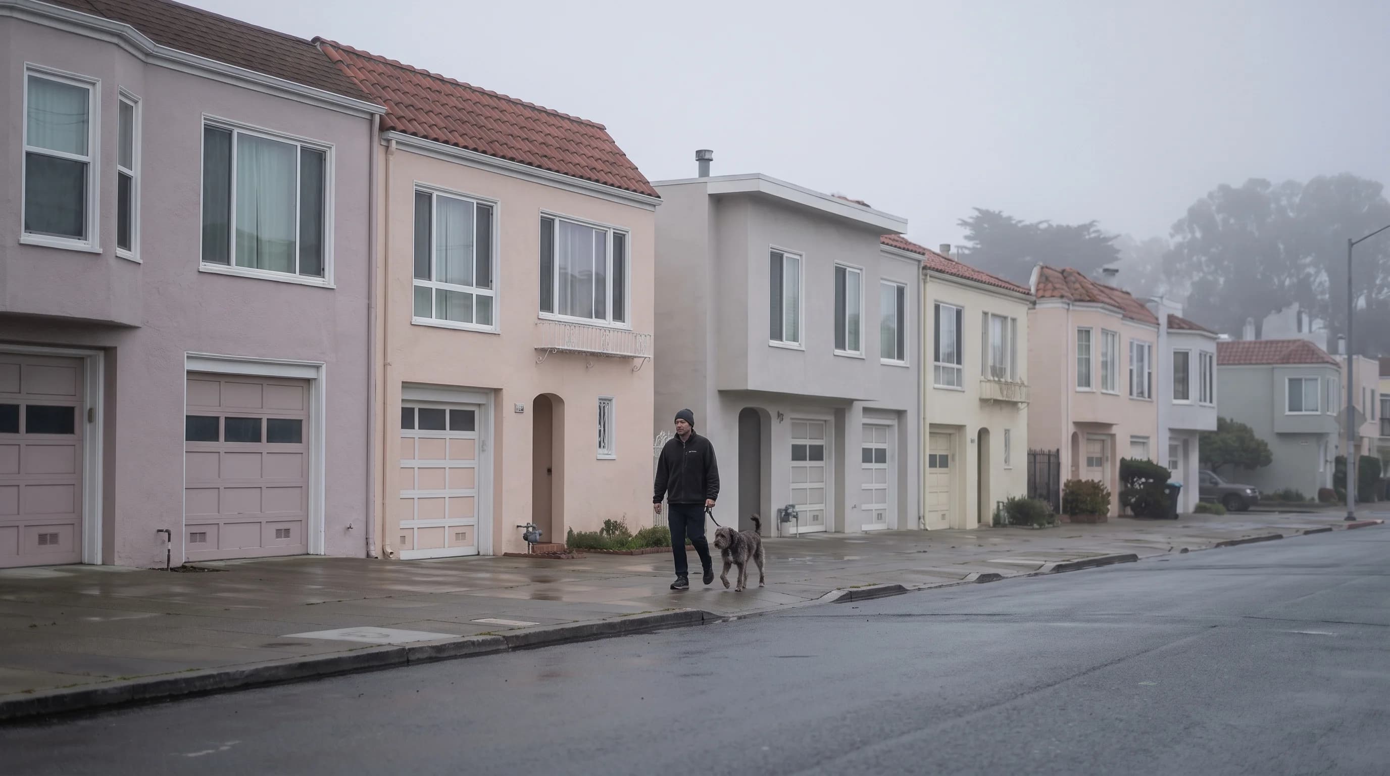 Low gray fog over a row of pastel houses on a west-side San Francisco street on a May morning